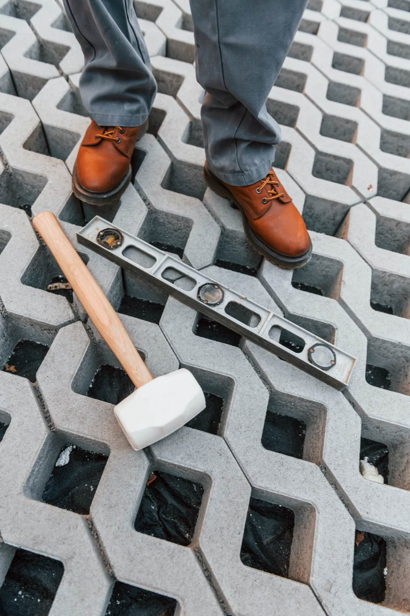 Lähikuva kumivasarasta ja vesivaakasta, jotka on asetettu betonilaatoille kivensijoitushankkeen aikana.